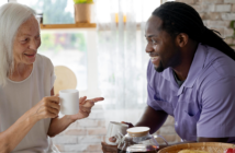 Person checking in on and visiting an elderly person.