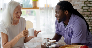 Person checking in on and visiting an elderly person.