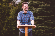 Friendly younger pastor preaching a sermon outdoors