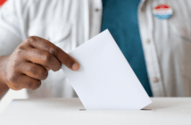 Person dropping their vote into the ballot box