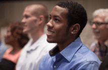 Smiling person sitting in a pew at a worship service
