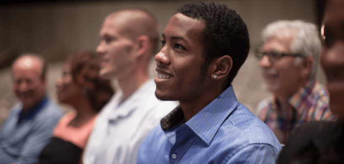 Smiling person sitting in a pew at a worship service