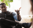 Person sitting on a couch with their legs crossed having a difficult conversation with another person
